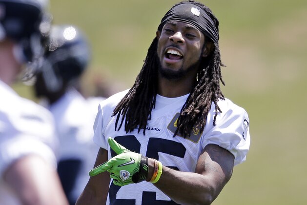 Seattle Seahawks' Richard Sherman motions to a teammate at an NFL organized team activity football practice Monday, June 2, 2014, in Renton, Wash. (AP Photo/Elaine Thompson)