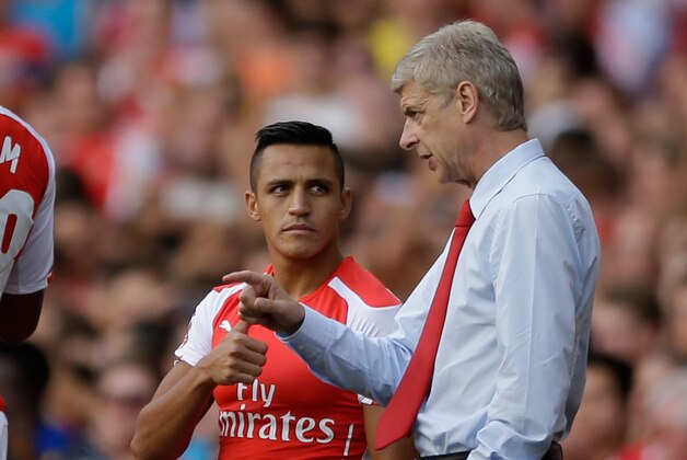 Arsenal's French manager Arsene Wenger, right, gives instructions to his new signing Alexis Sanchez as he substituted on to make his debut, during the Emirates Cup soccer match between between Arsenal and Benfica at Arsenal's Emirates Stadium in London, Saturday, Aug. 2, 2014.  (AP Photo/Matt Dunham)