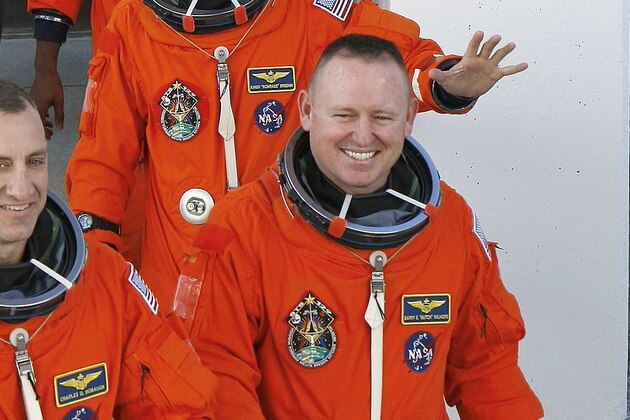 STS-129 crew members, front row from left, Commander Charles Hobaugh, Pilot Barry Wilmore, second row from left, Mission Specialist Leland Melvin, and Randy Bresnik, third row from left, Mike Foreman, and Robert Satcher smile and wave as they leave the Operations and Checkout Building Monday, Nov. 16, 2009 for a trip to launch pad 39-A and a planned liftoff onboard the Space Shuttle Atlantis. (AP Photo/ John Raoux)