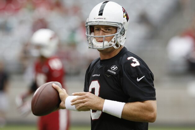 Arizona Cardinals' Carson Palmer flips the ball back to the center after he takes a snap during the first day of NFL football training camp on Saturday, July 26, 2014, in Glendale, Ariz. (AP Photo/Ross D. Franklin)