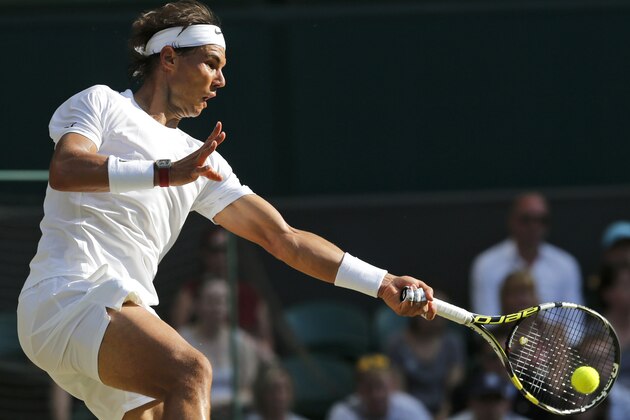Rafael Nadal of Spain plays a return to Nick Kyrgios of Australia during their men's singles match on Centre Court at the All England Lawn Tennis Championships in Wimbledon, London, Tuesday, July 1, 2014. (AP Photo/Ben Curtis)