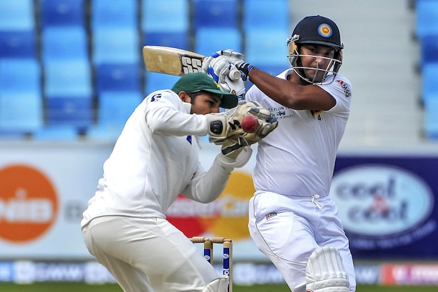 Kumar Sangakkara of Sri Lanka, right, hits the ball past Pakistan wicketkeeper Sarfraz Ahmed during the second cricket test match between Pakistan and Sri Lanka at the Dubai International Cricket Stadium in Dubai, United Arab Emirates, Sunday,  Jan. 12, 2014. (AP Photo/Stephen Hindley)