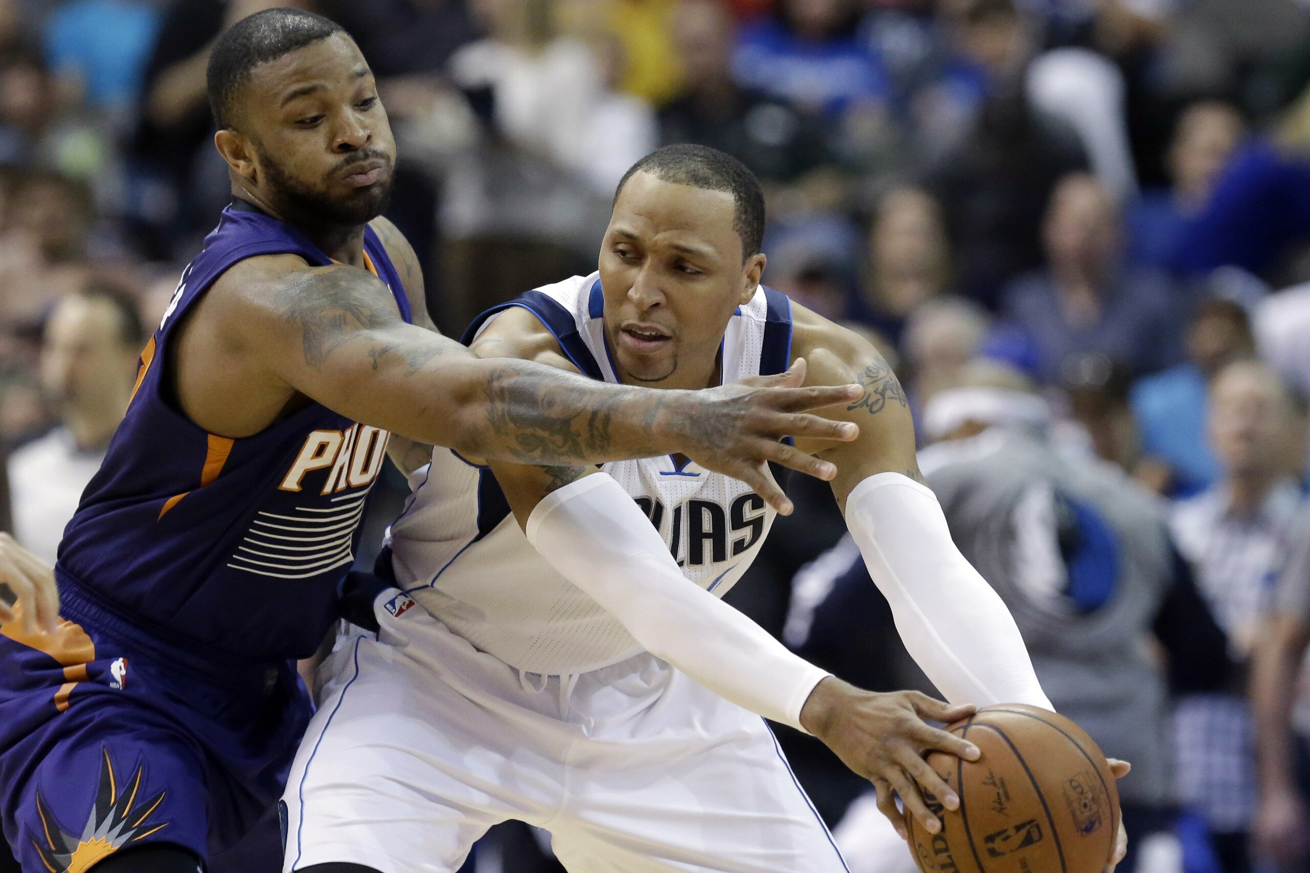 Dallas Mavericks forward Shawn Marion, right, keeps the ball from Phoenix Suns forward P.J. Tucker, left, during the first half of an NBA basketball game on Saturday, April 12, 2014, in Dallas. (AP Photo/LM Otero)