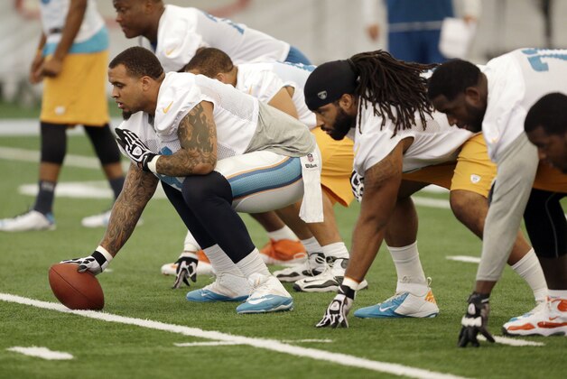 Miami Dolphins center Mike Pouncey prepares to snap the ball during mini-camp, Wednesday, June 18, 2014 at the Dolphins Training Facility in Davie, Fla. (AP Photo/Wilfredo Lee)