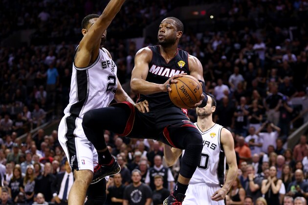 SAN ANTONIO, TX - JUNE 15:  Dwyane Wade #3 of the Miami Heat makes a pass as Tim Duncan #21 of the San Antonio Spurs defends during Game Five of the 2014 NBA Finals at the AT&T Center on June 15, 2014 in San Antonio, Texas. NOTE TO USER: User expressly acknowledges and agrees that, by downloading and or using this photograph, User is consenting to the terms and conditions of the Getty Images License Agreement.  (Photo by Andy Lyons/Getty Images)