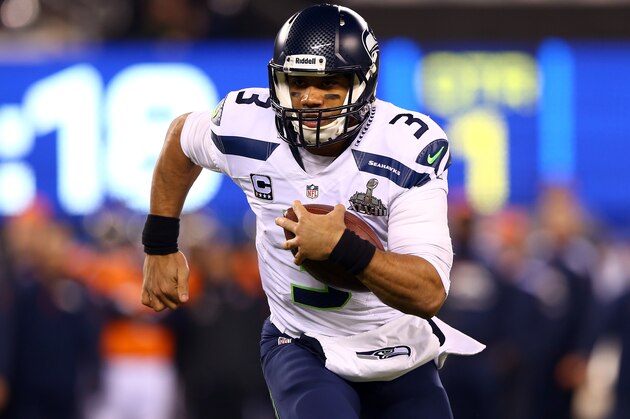 EAST RUTHERFORD, NJ - FEBRUARY 02:  Quarterback Russell Wilson #3 of the Seattle Seahawks runs the ball against the Denver Broncos during Super Bowl XLVIII at MetLife Stadium on February 2, 2014 in East Rutherford, New Jersey.  (Photo by Elsa/Getty Images)