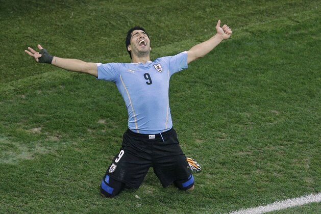 FILE - In this  June 19, 2014 file photo, Uruguay's Luis Suarez celebrates scoring 2-1 during the group D World Cup soccer match between Uruguay and England at the Itaquerao Stadium in Sao Paulo, Brazil. Barcelona reached agreement with Liverpool on the transfer of Luis Suarez on Friday July 11, 2014, giving the troubled striker a chance to rehabilitate his image when his latest biting ban is over. Suarez will travel to Barcelona next week for a medical and to sign a five-year contract. (AP Photo/Michael Sohn, File)