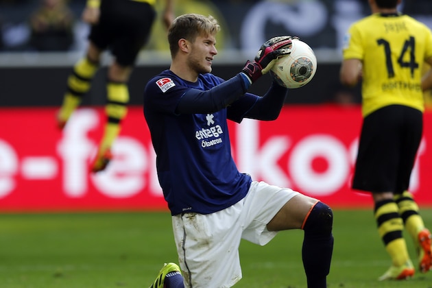 Mainz goalkeeper Loris Karius, center, holds the ball while Dortmund's Marco Reus, left, celebrates after scoring during the German first division Bundesliga soccer match between BvB Borussia Dortmund and Mainz 05 in Dortmund, Germany, Saturday, April 19, 2014. (AP Photo/Frank Augstein)