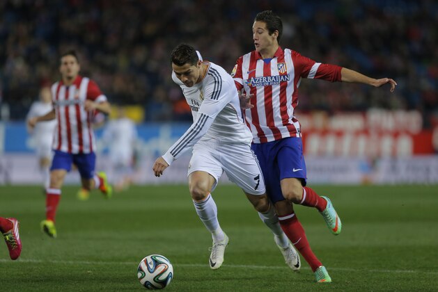 Atletico's Javi Manquillo, bottom, commits a foul on Real's Cristiano Ronaldo, front, during a semi final, 2nd leg, Copa del Rey soccer match between Atletico de Madrid and Real Madrid at the Vicente Calderon stadium in Madrid, Spain, Tuesday, Feb. 11, 2014. (AP Photo/Andres Kudacki)