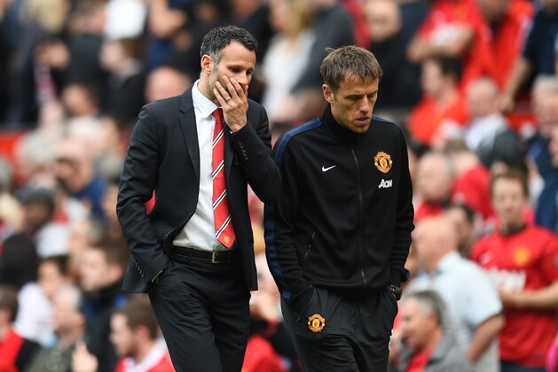 MANCHESTER, ENGLAND - MAY 03:  Ryan Giggs the Manchester United interim manager speaks with coach Phil Neville during the Barclays Premier League match between Manchester United and Sunderland at Old Trafford on May 3, 2014 in Manchester, England.  (Photo by Shaun Botterill/Getty Images)