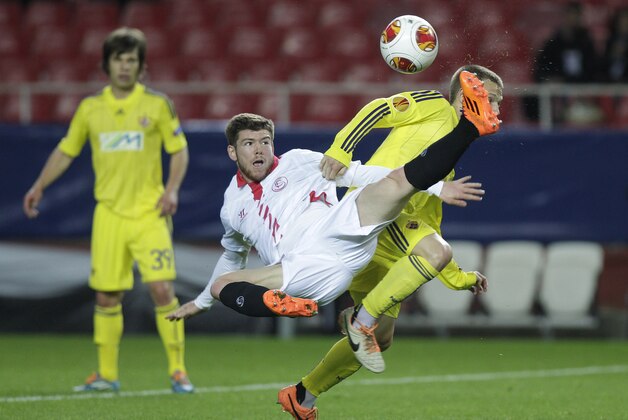 Sevilla's Alberto Moreno, center, and Maribor's Dejan Mezga, right, challenge for the ball during their Europa League round of 32 second leg soccer match at the Ramon Sanchez Pizjuan stadium in Seville, Spain Thursday, Feb. 27, 2014. (AP Photo/Toni Rodriguez)