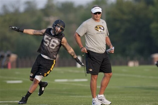 Missouri's Shane Ray, left, runs around head coach Gary Pinkel during NCAA college football practice Tuesday, Aug. 5, 2014, in Columbia, Mo. Missouri started their football practice this week. (AP Photo/L.G. Patterson)