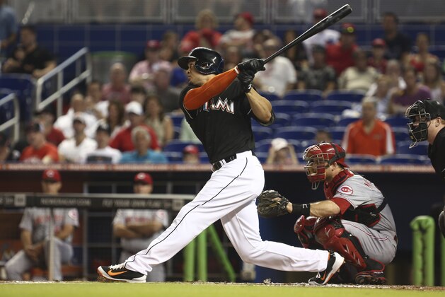 Cincinnati Reds catcher Devin Mesoraco and Miami Marlins batter Giancarlo Stanton watch as Stanton hits a double during the first inning of a baseball game in Miami, Saturday, Aug. 2, 2014. (AP Photo/J Pat Carter)
