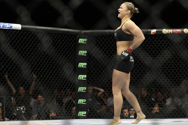 Ronda Rousey celebrates after defeating Alexis Davis in their women's mixed martial arts bantamweight title bout at UFC 175 Saturday, July 5, 2014, in Las Vegas. (AP Photo/John Locher)
