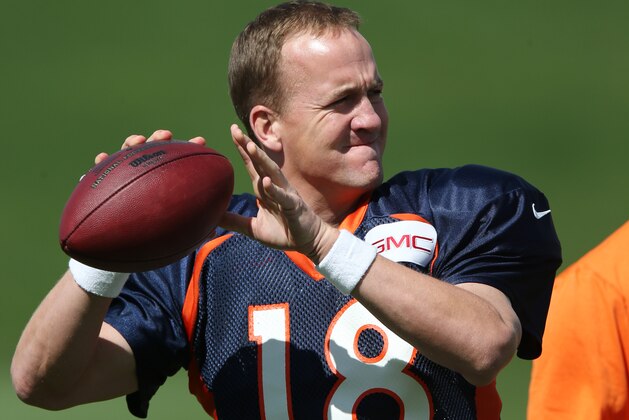 Denver Broncos quarterback Peyton Manning warms up during the morning session at the team's NFL training camp at Broncos headquarters in Englewood, Colo., on Friday, Aug. 1, 2014. (AP Photo/David Zalubowski)