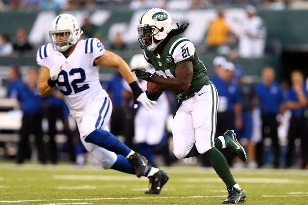 EAST RUTHERFORD, NJ - AUGUST 07: Running back Chris Johnson #21 of the New York Jets carries the ball against outside linebacker Bjoern Werner #92 of the Indianapolis Colts during a preseason game at MetLife Stadium on August 7, 2014 in East Rutherford, New Jersey.  (Photo by Elsa/Getty Images)