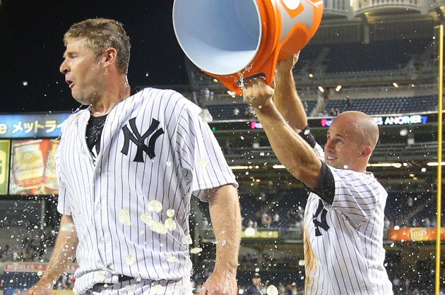 Jul 22, 2014; Bronx, NY, USA; New York Yankees left fielder Brett Gardner (11) dumps Gatorade on third baseman Chase Headley (12) after Headley's game-winning walk off single against the Texas Rangers during a game at Yankee Stadium. Mandatory Credit: Brad Penner-USA TODAY Sports