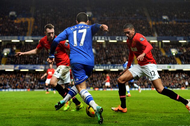 LONDON, ENGLAND - JANUARY 19:  Eden Hazard of Chelsea is challenged by Phil Jones (L) and Chris Smalling (R) of Manchester United during the Barclays Premier League match between Chelsea and Manchester United at Stamford Bridge on January 19, 2014 in London, England.  (Photo by Mike Hewitt/Getty Images)