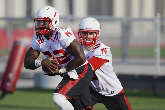 Nebraska quarterback Johnny Stanton, right, hands off the ball to running back Imani Cross during Nebraska's first day of NCAA college football practice in Lincoln, Neb., Monday, Aug. 4, 2014. (AP Photo/Nati Harnik)