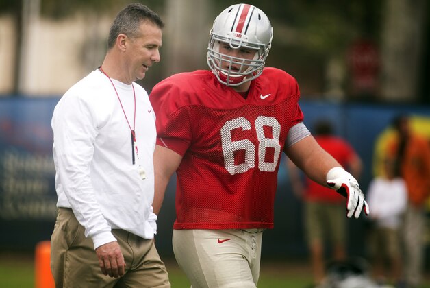 Ohio State coach Urban Meyer talks to Taylor Decker (68) during NCAA college football practice Tuesday, Dec. 31, 2013, in Davie Fla.  Ohio State takes on Clemson in the Orange Bowl on Friday, Jan. 3, 2014. (AP Photo/J Pat Carter)