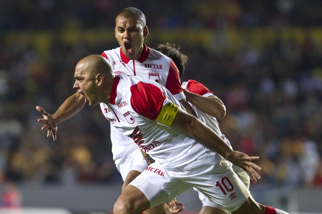 Omar Perez Colombia's Indepentiente, center, celebrates with teammate with Sergio Otalvaro, after Perez scored against Morelia in a Copa Libertadores soccer match in Morelia, Mexico, Tuesday, Jan. 28, 2014. (AP Photo/Christian Palma)