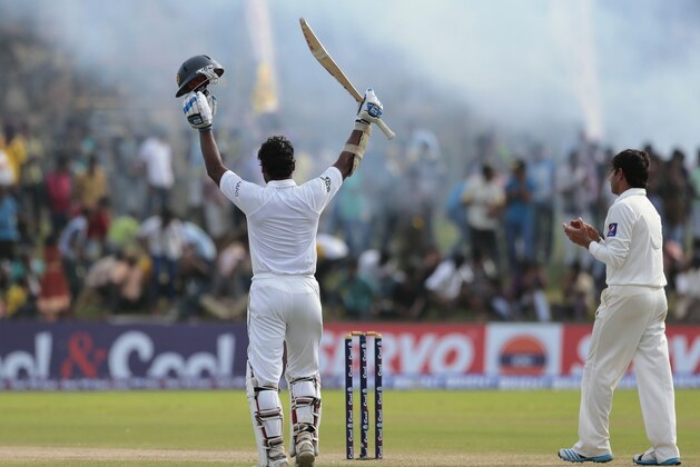 Sri Lankan batsman Kumar Sangakkara, left, celebrates scoring a double century as Pakistan's Saeed Ajmal applauds during the fourth day of the first test cricket match between Sri Lanka and Pakistan in Galle, Sri Lanka, Saturday, Aug. 9, 2014. (AP Photo/Eranga Jayawardena)