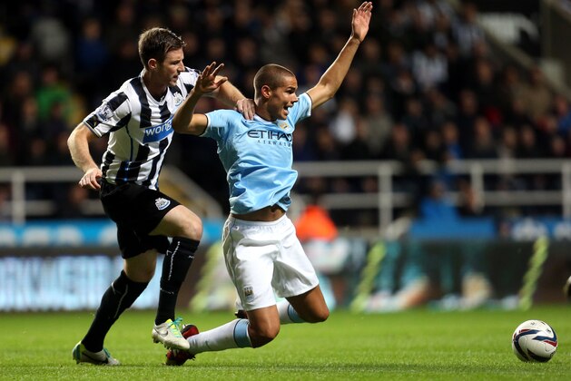 Manchester City's Jack Rodwell, centre, vies for the ball with Newcastle United's Mike Williamson, left, during their English League Cup soccer match at St James' Park, Newcastle, England, Wednesday, Oct. 30, 2013. (AP Photo/Scott Heppell)