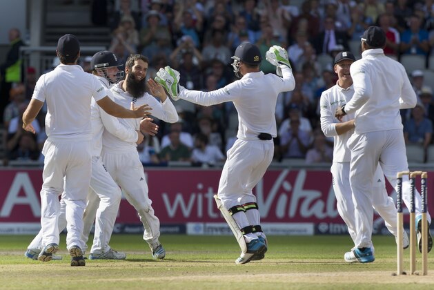 England's Moeen Ali, center left, celebrates with teammates after taking the wicket of India's Ajinkya Rahane for 1 on the third day of the fourth test match of their five match series at Old Trafford cricket ground, in Manchester, England, Saturday, Aug. 9, 2014. (AP Photo/Jon Super)