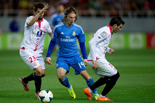 SEVILLE, SPAIN - MARCH 26: Luka Modric (2ndL) of Real Madrid CF competes for the ball with Jorge Andujar Moreno alias Coke (L) of Sevilla FC and his teammate Jose Antonio Reyes during the La Liga match between Sevilla FC and Real Madrid CF at Estadio Ramon Sanchez Pizjuan on March 26, 2014 in Seville, Spain.  (Photo by Gonzalo Arroyo Moreno/Getty Images)