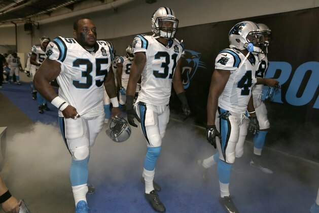 Carolina Panthers players , from left, Mike Tolbert, James Dockery, and Colin Jones, walk down the tunnel toward the field before a preseason NFL football game against the Buffalo Bills in Charlotte, N.C., Friday, Aug. 8, 2014. (AP Photo/Chuck Burton)