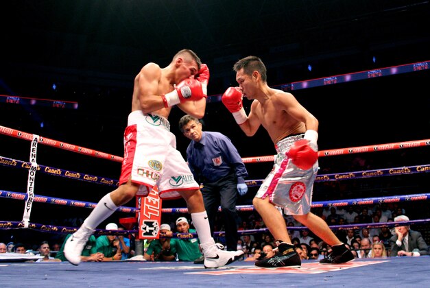 Mexico's Francisco Rodriguez, left, exchanges a punch with Japan's Katsunari Takayama, during their  IBF and WBO minimumweight title unification  in Monterrey, Mexico, Saturday Aug. 9, 2014. (AP Photo/Alfredo Lopez)