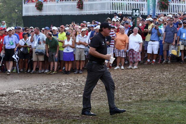 Aug 10, 2014; Louisville, KY, USA; PGA golfer Phil Mickelson walks through the mud on the 14th fairway during the final round of the 2014 PGA Championship golf tournament at Valhalla Golf Club. Mandatory Credit: Brian Spurlock-USA TODAY Sports
