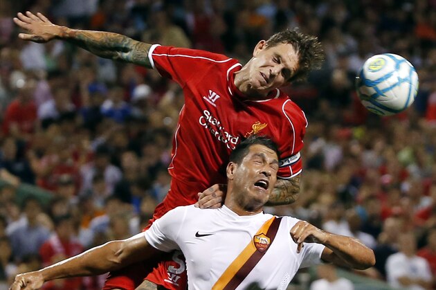 Liverpool FC defender Daniel Agger, top, challenges AS Roma's Marco Borriello (9) for the ball during a friendly soccer match at Fenway Park in Boston, Wednesday, July 23, 2014. (AP Photo)