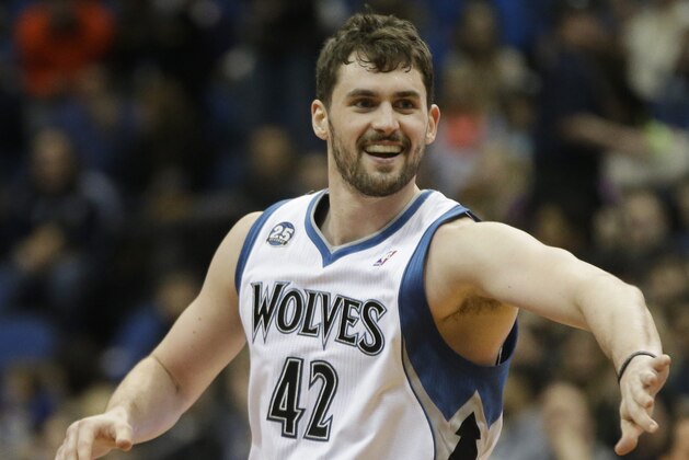 Minnesota Timberwolves' Kevin Love, left, congratulates Corey Brewer after Brewer's dunk in the first quarter of an NBA basketball game against the Detroit Pistons, Friday, March 7, 2014, in Minneapolis. (AP Photo/Jim Mone)