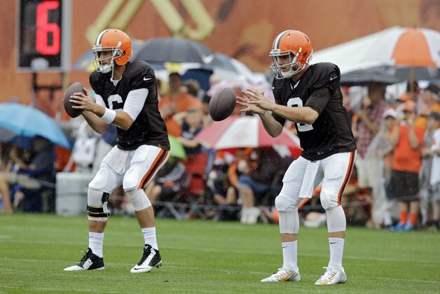 Cleveland Browns quarterbacks Brian Hoyer, left, and Johnny Manziel take snaps during practice at NFL football training camp in Berea, Ohio on Monday, Aug. 11, 2014. (AP Photo/Mark Duncan)