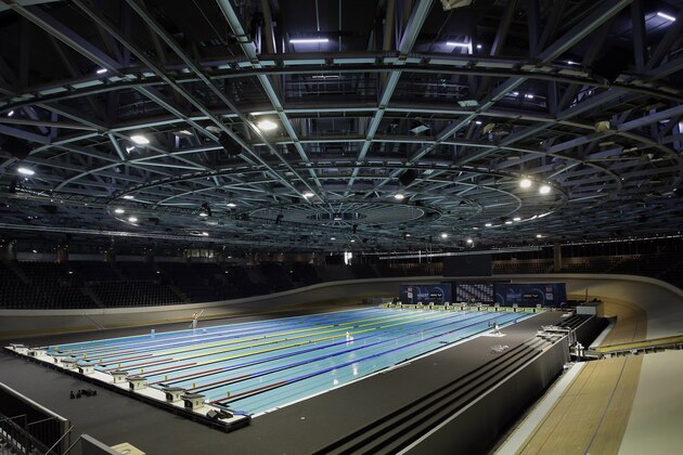 Workers put finishing touches on the temporary pool for the swimming events, built in the center of the cycling track of the velodrome arena  in Berlin, Germany, Monday, Aug. 11, 2014. The European Swimming Championships 2014 take place in the German capital Berlin from Aug. 13 until Aug. 24, 2014.  (AP Photo/Michael Sohn)