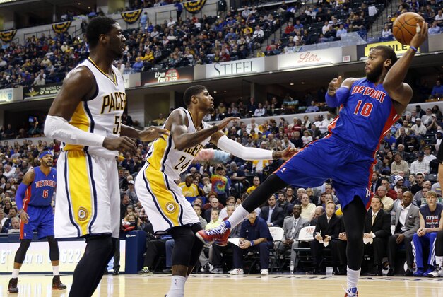 Dec 16, 2013; Indianapolis, IN, USA; Detroit Pistons center Greg Monroe (10) saves the ball from going out of bounds while guarded by Indiana Pacers center Roy Hibbert (55) and forward Paul George (24) at Bankers Life Fieldhouse. Mandatory Credit: Brian Spurlock-USA TODAY Sports