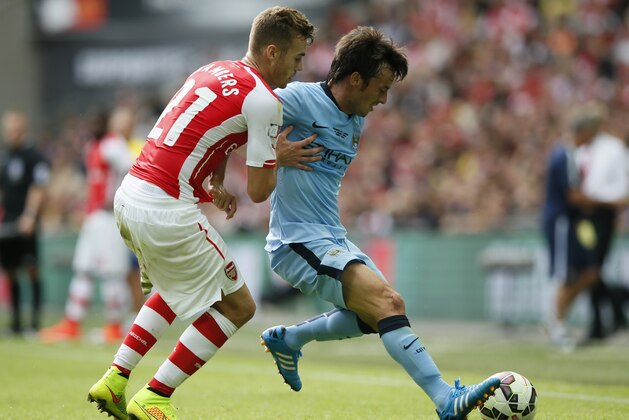 Arsenal's Calum Chambers, left,  challenges Manchester City's David Silva during the English FA Community Shield soccer match at Wembley Stadium, London Sunday, Aug. 10, 2014. (AP Photo/Alastair Grant)