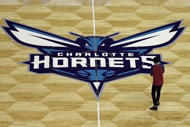 A photographer takes photos of the Charlotte Hornets logo during a news conference to unveil the design for their home court in Charlotte, N.C., Thursday, June 26, 2014. (AP Photo/Chuck Burton)