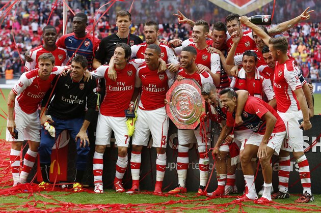 Arsenal's team celebrate their win against Manchester City with the trophy at the end of their English Community Shield soccer match at Wembley Stadium in London, Sunday, Aug. 10, 2014. (AP Photo/Sang Tan)