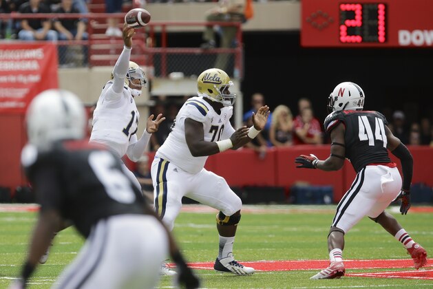 UCLA quarterback Brett Hundley (17) throws behind UCLA offensive tackle Simon Goines (70) who is facing Nebraska defensive end Randy Gregory (44), in the second half of an NCAA college football game in Lincoln, Neb., Saturday, Sept. 14, 2013. UCLA defeated Nebraska 41-21. (AP Photo/Nati Harnik)