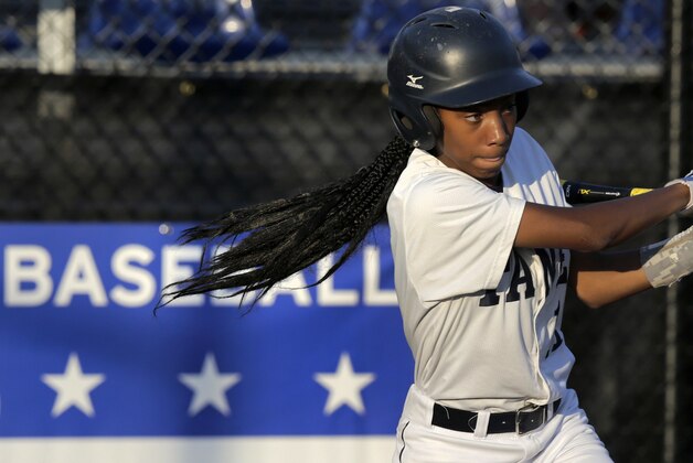 In this Aug. 6, 2014 photo, Pennsylvania's Mo'Ne Davis follows through on a single against the District of Columbia during a baseball game in the Little League Eastern Regionals at Breen Stadium in Bristol, Conn. Davis and New Jersey's Kayla Roncin are competing to make it to the Little League World Series, a rare feat for girls.  (AP Photo/Charles Krupa)