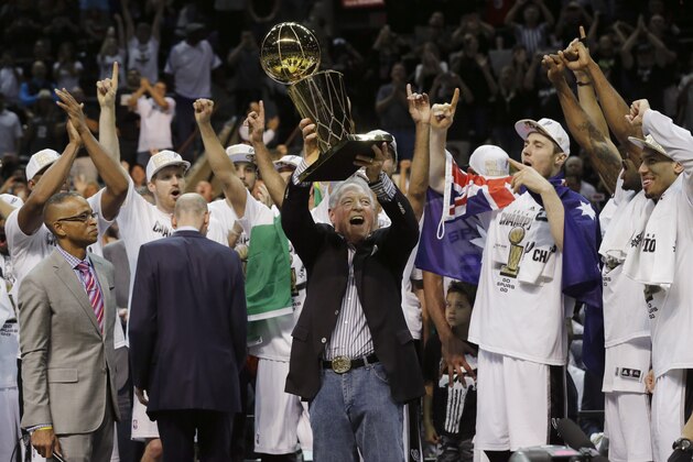San Antonio Spurs owner Peter Holt holds up the Larry O'Brien NBA Championship Trophy after Game 5 of the NBA basketball finals against the Miami Heat on Sunday, June 15, 2014, in San Antonio. The Spurs won the NBA championship 104-87.  (AP Photo/David J. Phillip)
