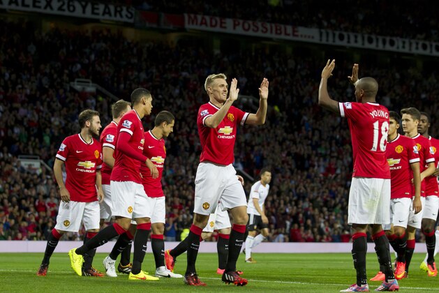 Manchester United's Darren Fletcher, centre, celebrates with teammates after scoring against Valencia, during a pre season friendly soccer match at Old Trafford Stadium, Manchester, England, Tuesday Aug. 12, 2014. (AP Photo/Jon Super)