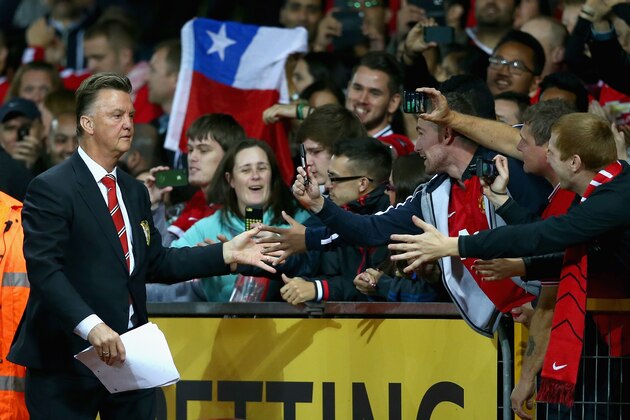 MANCHESTER, ENGLAND - AUGUST 12:  Manchester United manager Louis Van Gaal is congratulated by the fans after winning his home debut in the Pre Season Friendly match between Manchester United and Valencia at Old Trafford on August 12, 2014 in Manchester, England.  (Photo by Clive Brunskill/Getty Images)
