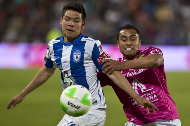 Pachuca's Hirving Lozano, left, fights for the ball with Leon's Edwin Hernandez during the final match of the Mexican soccer league in Pachuca, Sunday, May 18, 2014. (AP Photo/Christian Palma)