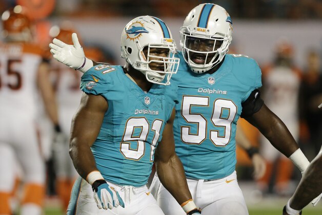 Miami Dolphins middle linebacker Dannell Ellerbe (59) congratulates Miami Dolphins defensive end Cameron Wake (91) after Wake recovered a fumble by Cincinnati Bengals quarterback Andy Dalton (14) during the first half of an NFL football game, Thursday, Oct. 31, 2013, in Miami Gardens, Fla. (AP Photo/Wilfredo Lee)