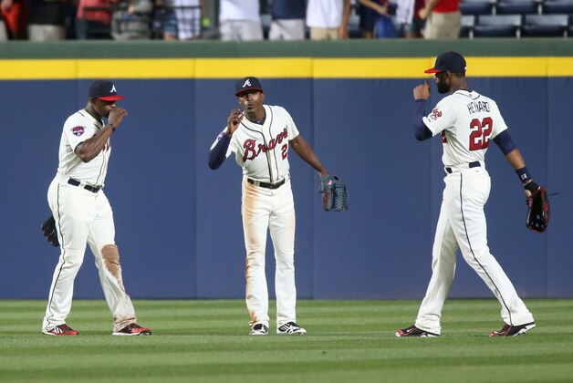 Atlanta Braves outfielders Justin Upton, left, B.J. Upton, center, and Jason Heyward celebrate their win over the Washington Nationals in their baseball game Saturday, April 12, 2014, in Atlanta. Atlanta won 6-3. (AP Photo/Jason Getz)