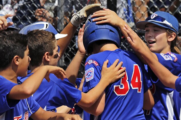 In this Aug. 6, 2014, photo, New Jersey's Kayla Roncin, of Toms River, N.J., right, congratulates teammate Christian Wood (34) on his home run against Delaware in a baseball game at the Little League Eastern Regionals at Breen Stadium in Bristol, Conn. Roncin and Pennsylvania's Mo’Ne Davis are competing to make it to the Little League World Series, a rare feat for girls. But to get there, one girls’ team may have to knock off the other’s team. (AP Photo/Charles Krupa)