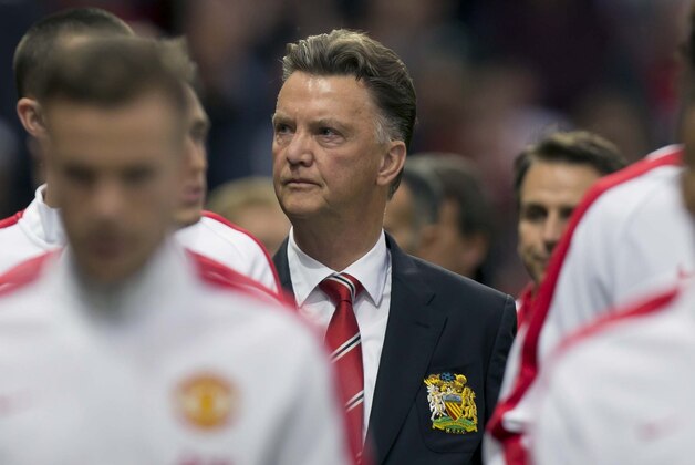 Manchester United's new manager Louis van Gaal, centre,  takes to the touchline before his team's pre season friendly soccer match against Valencia at Old Trafford Stadium, Manchester, England, Tuesday Aug. 12, 2014. (AP Photo/Jon Super)